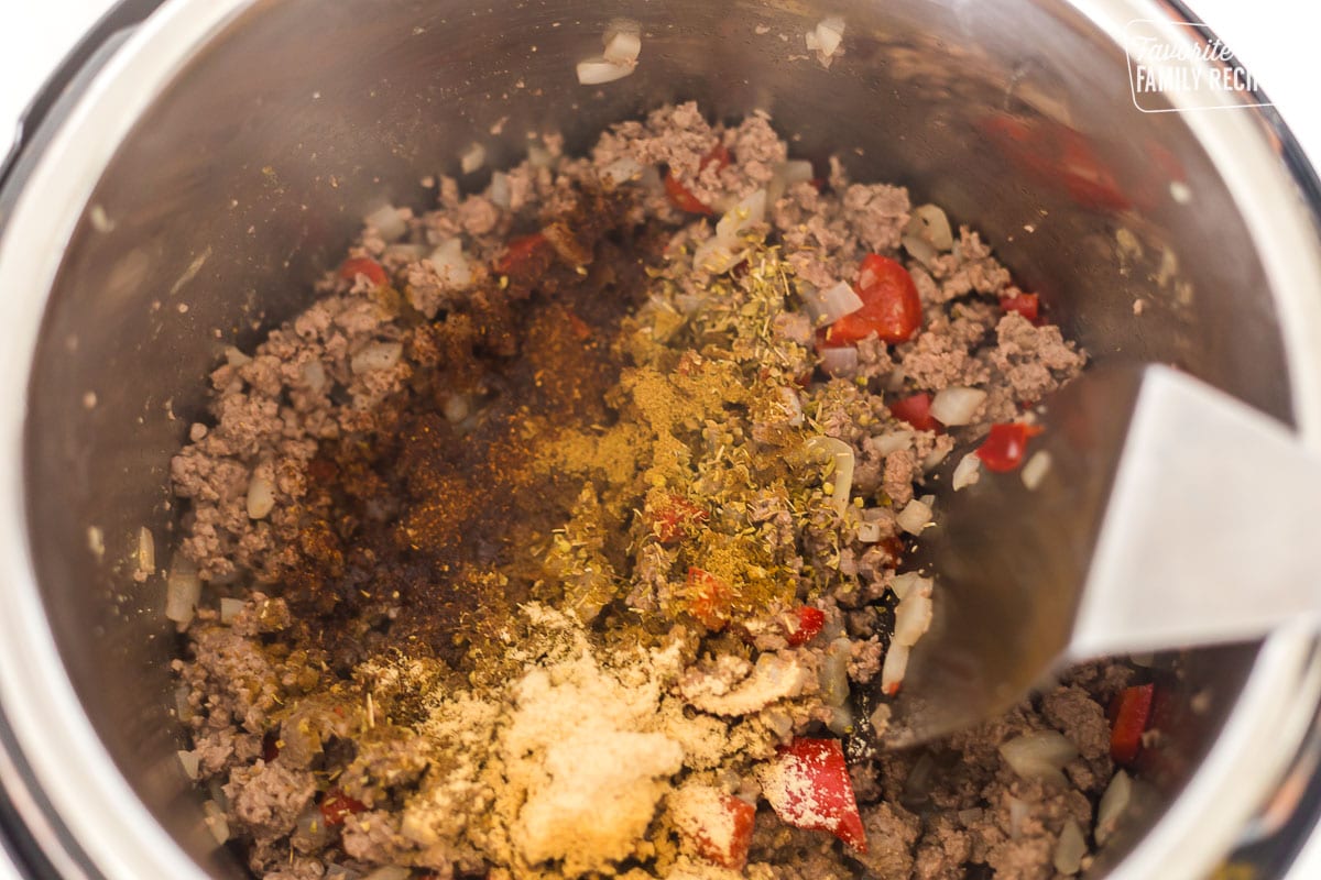 Cooked ground beef in an Instant Pot with seasonings over the top