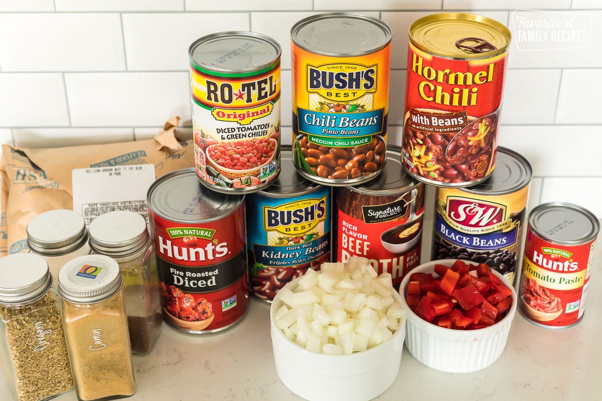 Ingredients to make Instant Pot chili including cans of beans, chopped onion and peppers, spices, and ground beef.