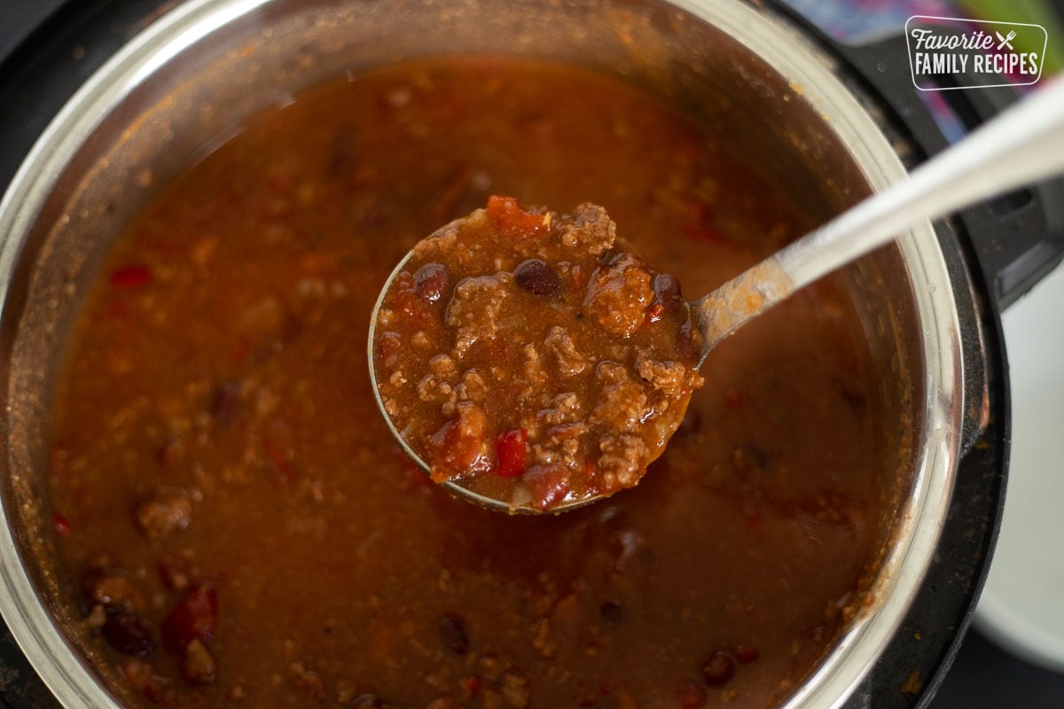 A ladle taking a large scoop from a pot of Instant Pot chili.