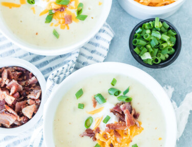 Two bowls of Instant pot potato soup with cheese, bacon, and green onion