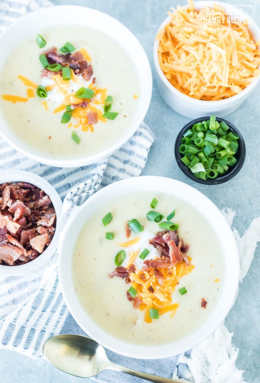 Two bowls of Instant pot potato soup with cheese, bacon, and green onion