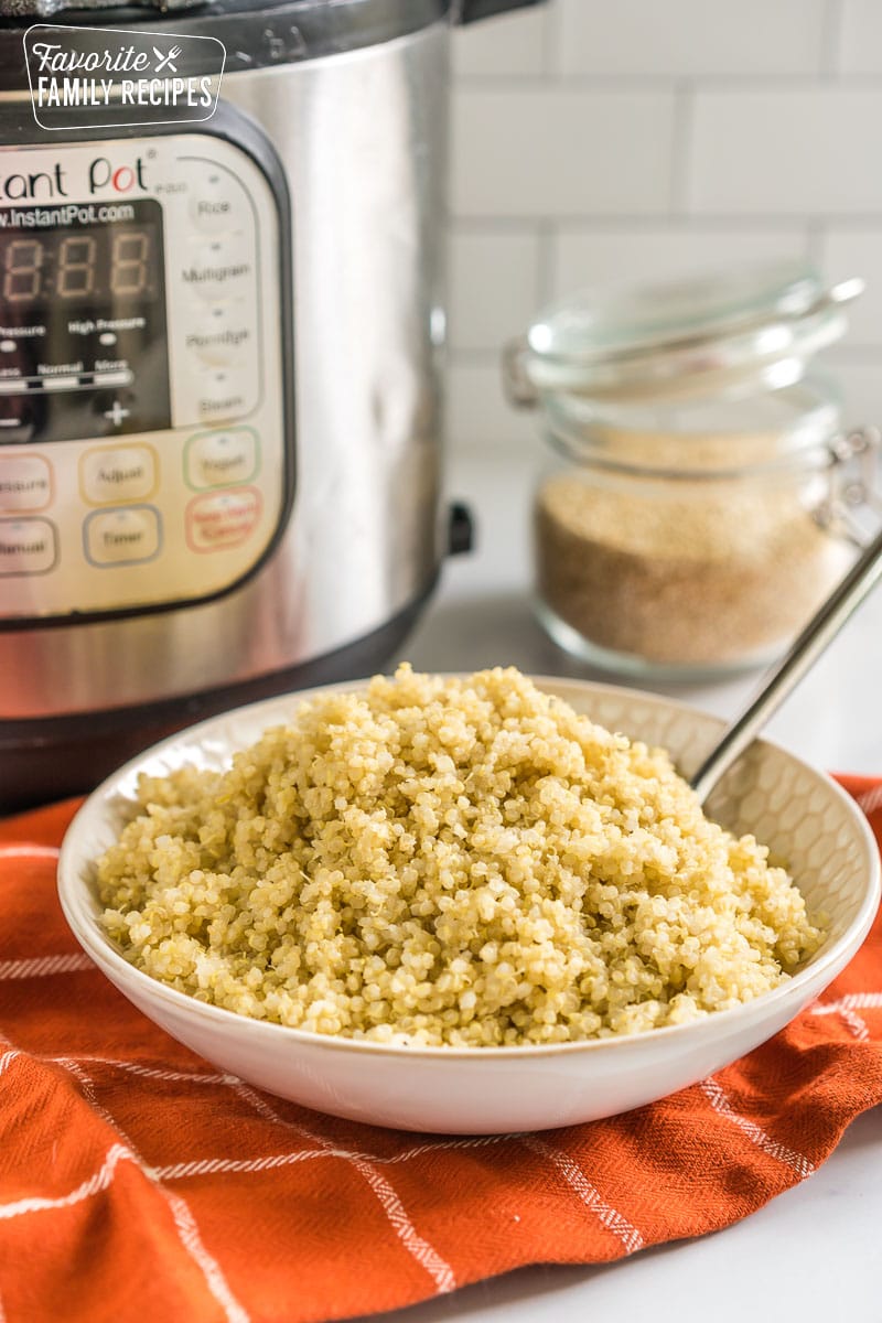 Quinoa in a bowl with an instant pot behind it.