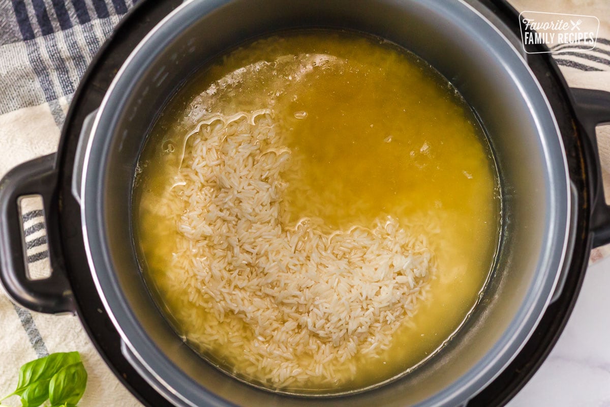 Instant Pot filled with chicken broth and rice to make Instant Pot Chicken and Rice.