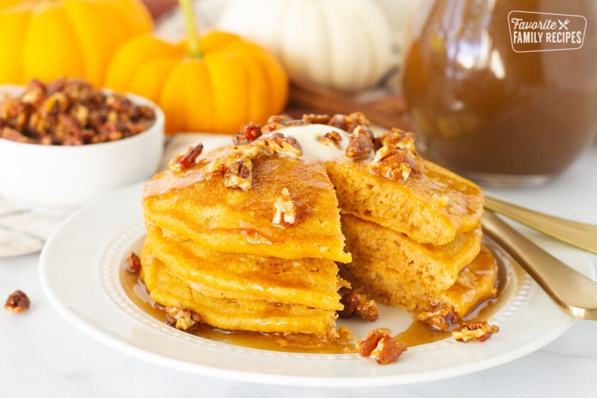 Pumpkin Pancakes with syrup and candied pecans missing a cut out.