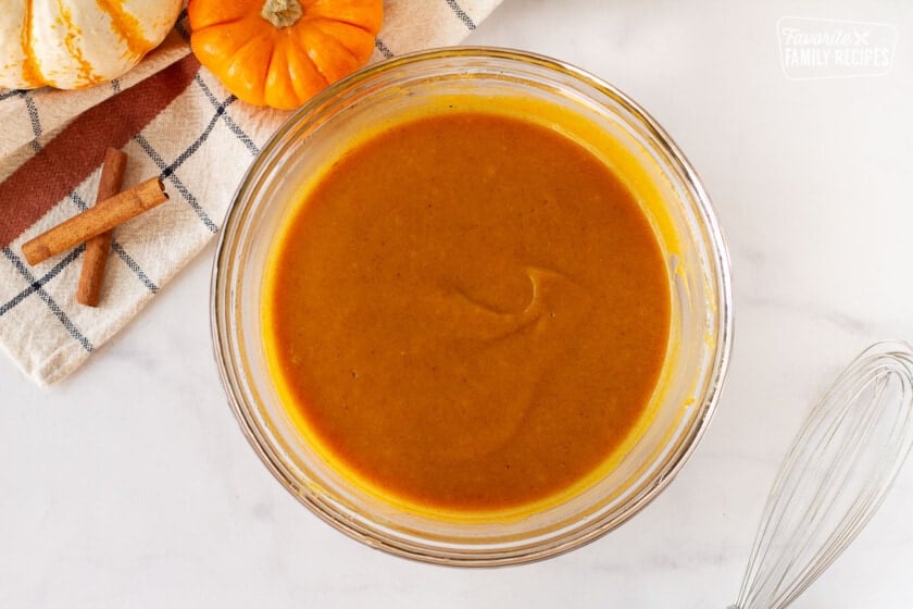 Bowl of pumpkin puree, oil and sour cream for Pumpkin Coffee Cake. Whisk on the side.