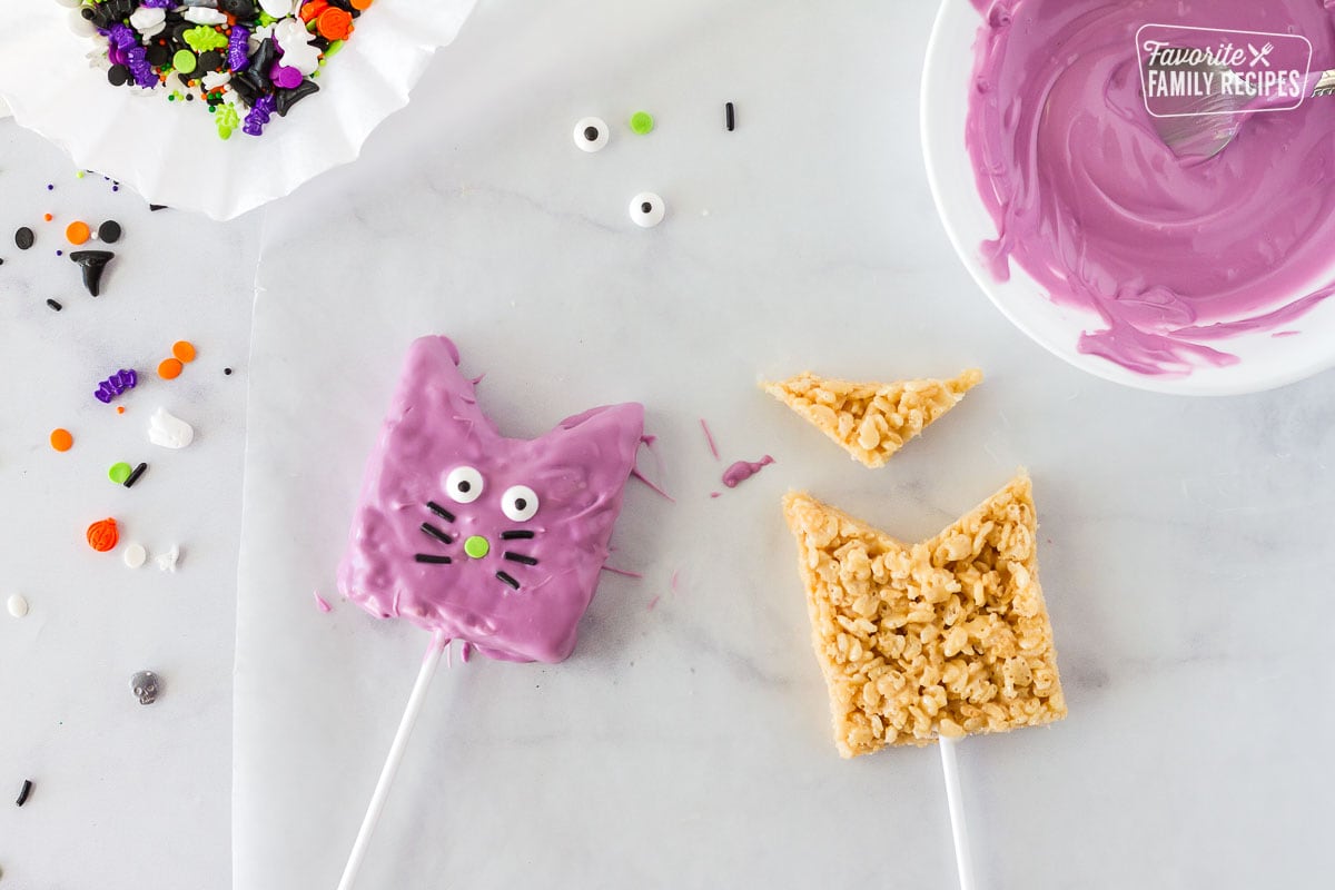 Shaped Rice Krispie treats on sticks and dipped in purple chocolate to look like cats