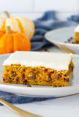Side view of two slices of Pumpkin Sheet Cake on serving plates with spoons.