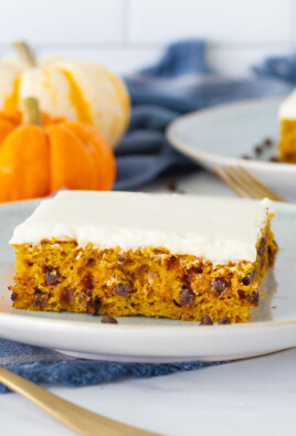 Side view of two slices of Pumpkin Sheet Cake on serving plates with spoons.