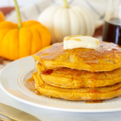 Three Pumpkin Pancakes with butter and syrup.