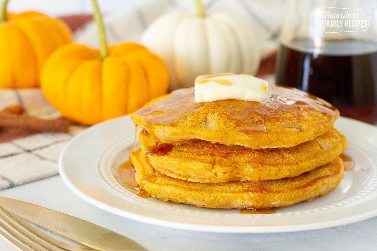 Three Pumpkin Pancakes with butter and syrup.