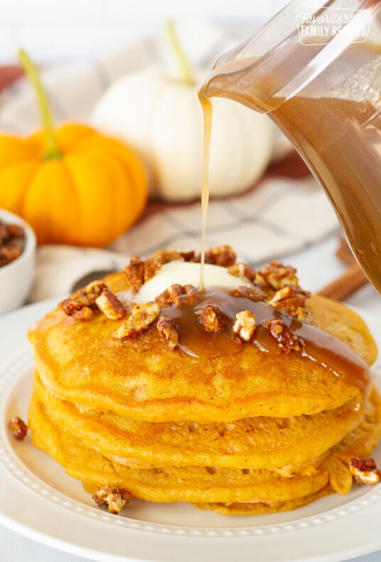 Syrup pouring onto a stack of three Pumpkin Pancakes.