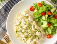 Top view of Instant Pot Chicken and Rice with silverware on the side. Green salad served on the side.