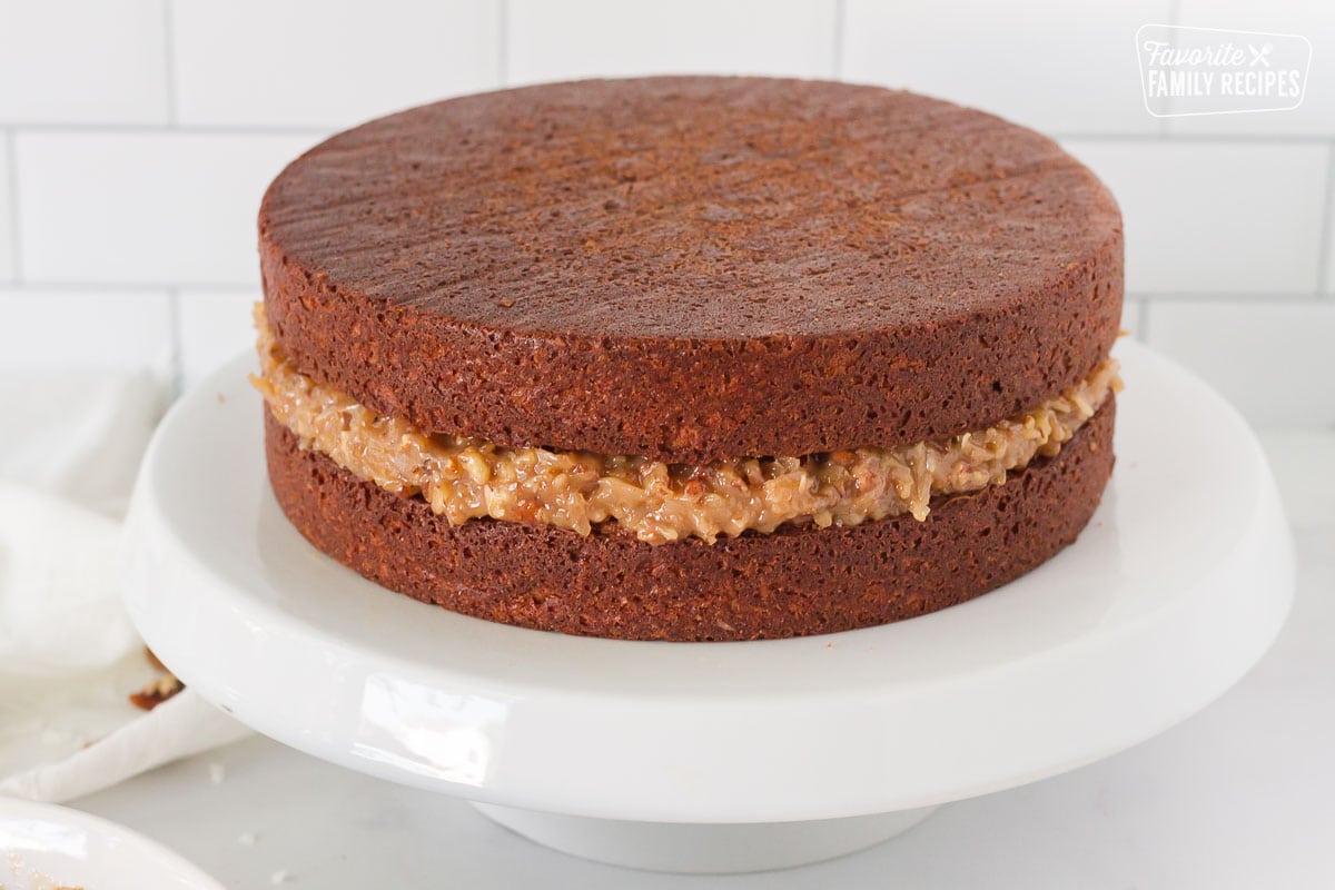 Two layers of German Chocolate Cake stacked with Coconut Pecan Frosting between.