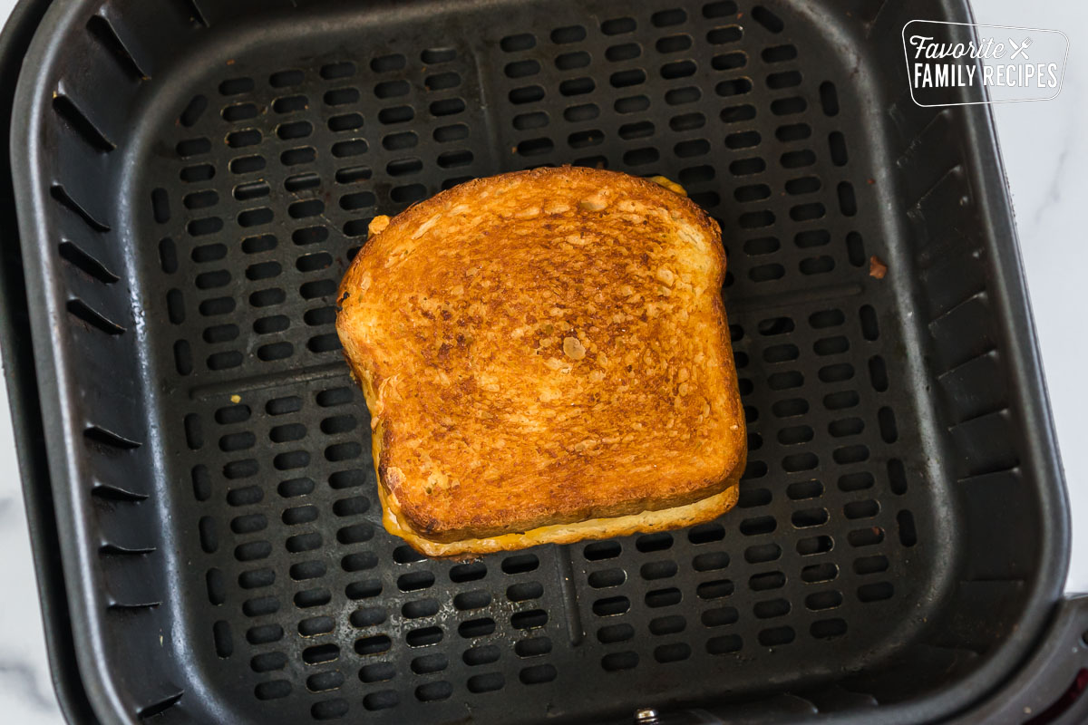 A grilled cheese sandwich in an air fryer basket