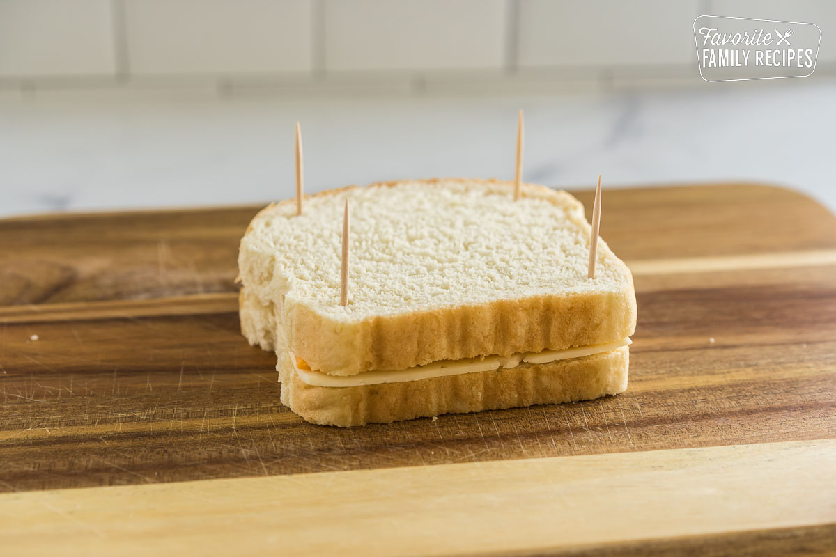 A cheese sandwich held together by toothpicks.