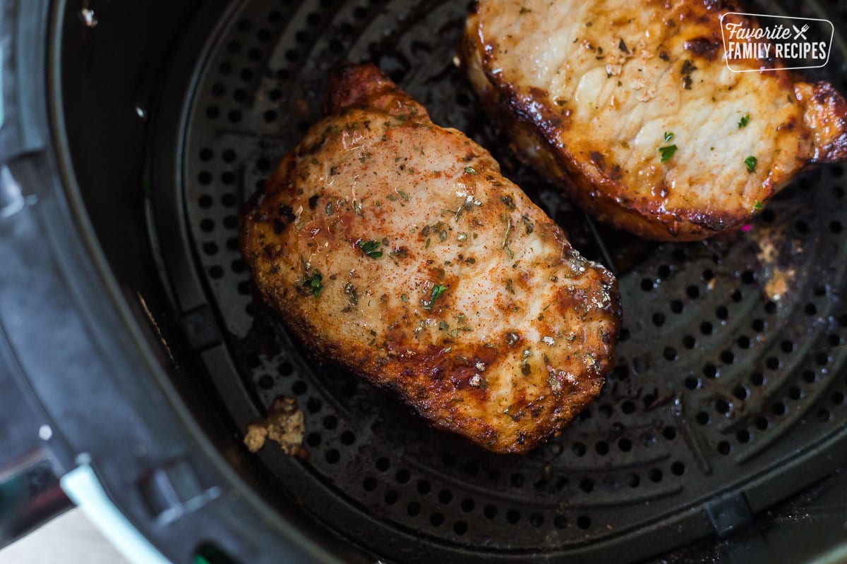 Cooked pork chops in an air fryer basket