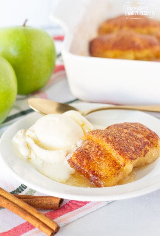 Apple Dumpling on a plate with ice cream and a spoon.