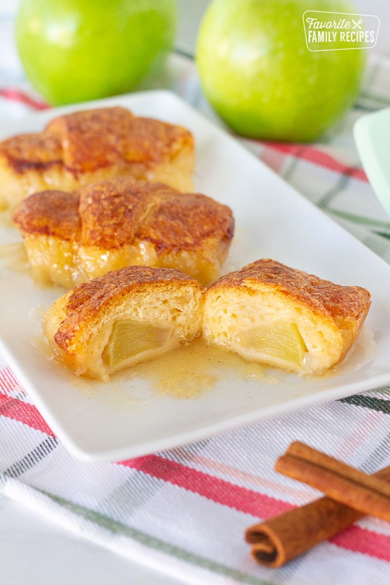 Three Apple Dumplings on a plate with the front one cut in half.