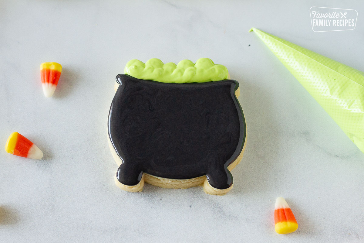 Green icing added to the top of the Cauldron Halloween Cookie .