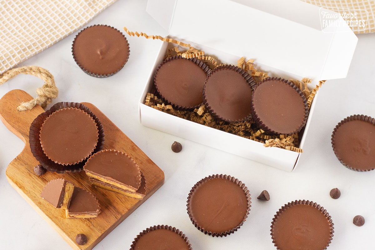Homemade Reese's Peanut Butter Cups boxed and cut up on a board.
