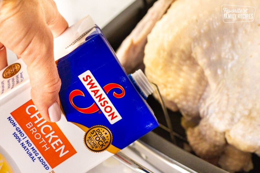 Chicken broth pouring into roasting pan for How to Cook a Turkey.