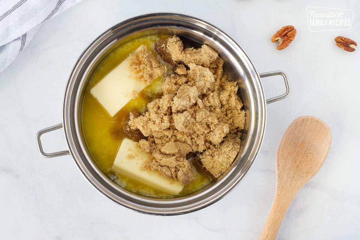 Pot of butter sticks and brown sugar for Easy Monkey Bread. Wooden spoon on the side.