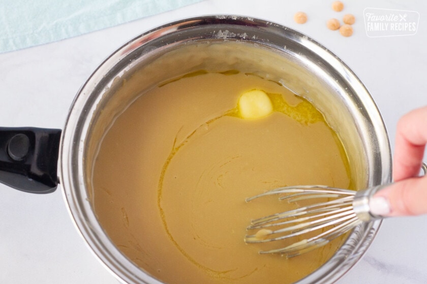 Stirring butter with a whisk in hot Butterscotch Pie filling.