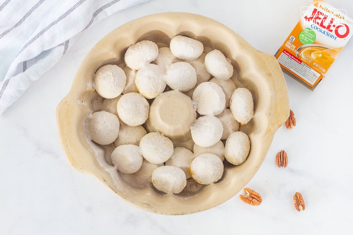 Dry butterscotch pudding sprinkled on top of frozen bread rolls for Easy Monkey Bread.