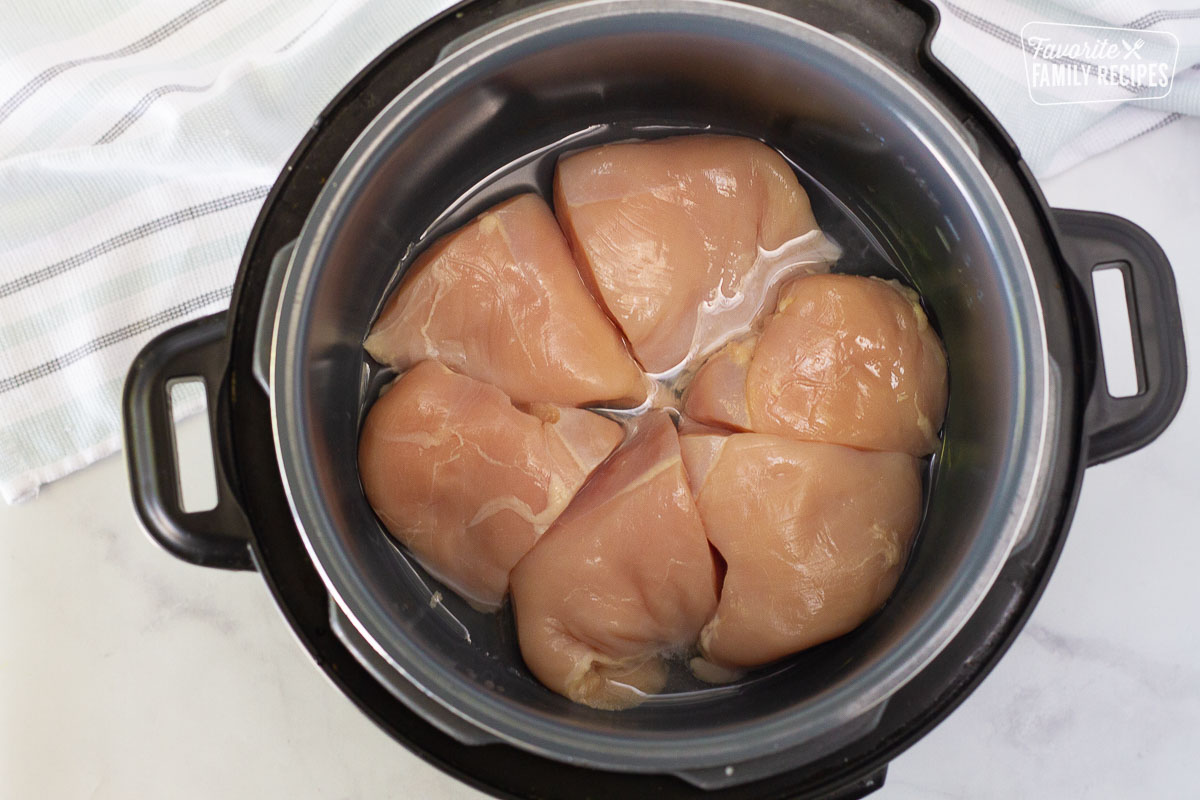 Instant pot with water and cooked chicken for Apricot Chicken.