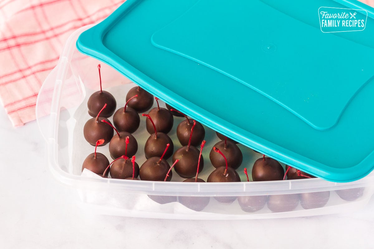 Chocolate Covered Cherries being stored in a Tupperware container.