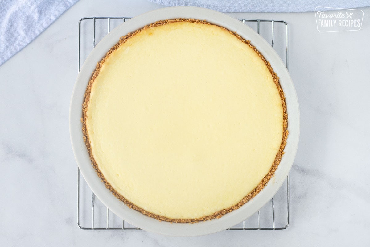 Baked cheesecake on a cooling rack to show How to Make a Cheesecake.