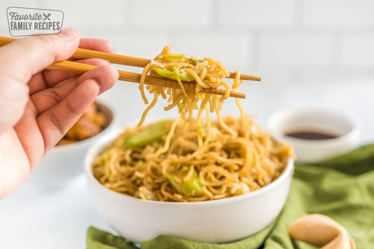 Chopsticks holding a bite of chow mein noodles