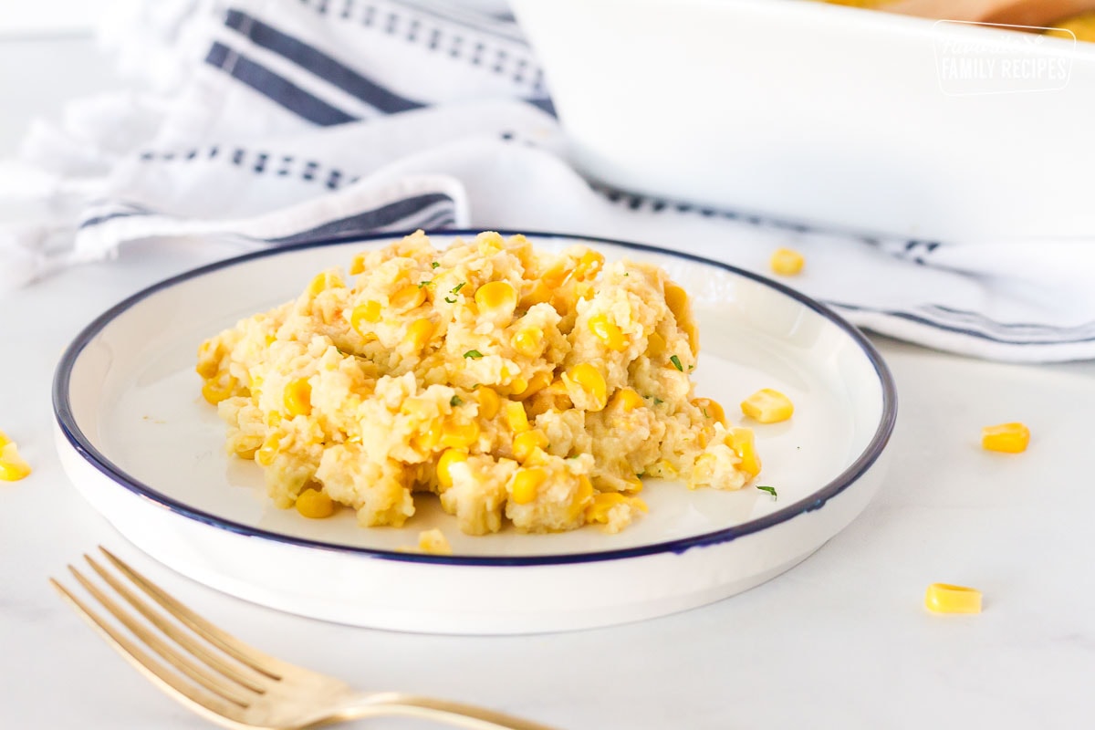 Plate of Corn Casserole next to the baking dish.