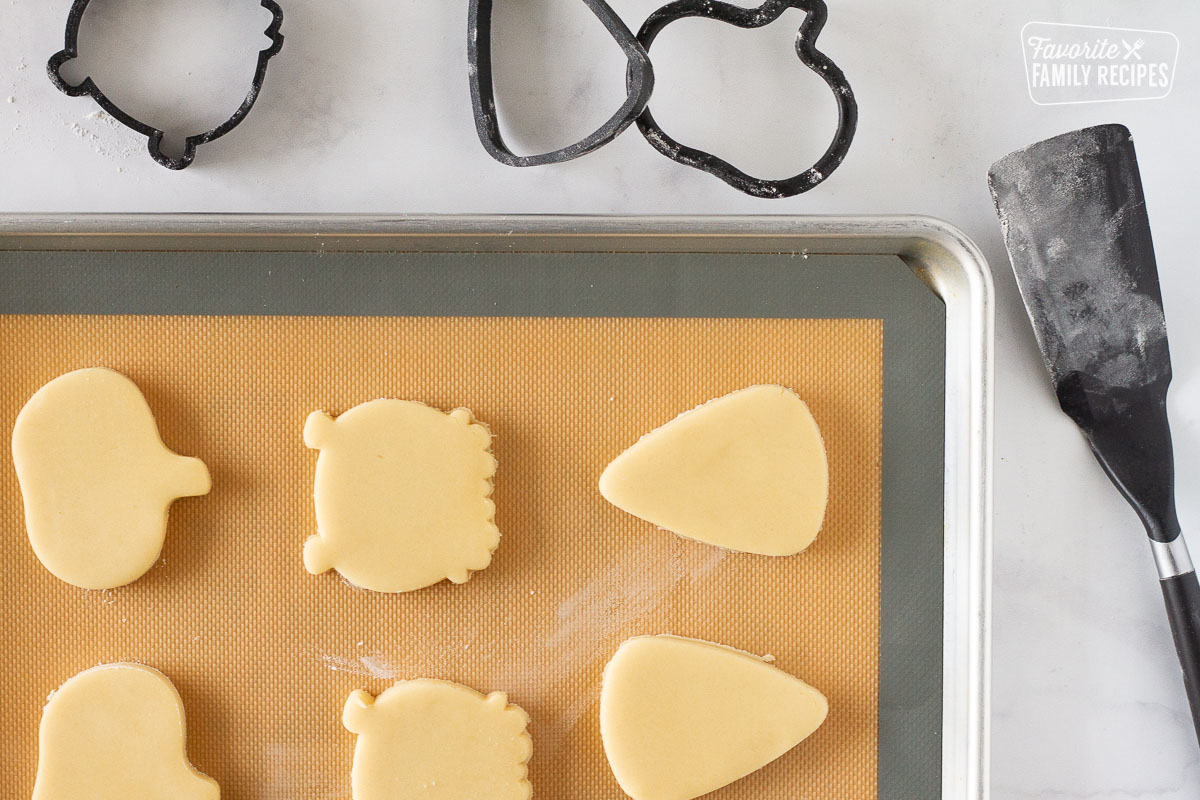 Unbaked cut out Halloween shaped Cookies on a Cookie sheet.