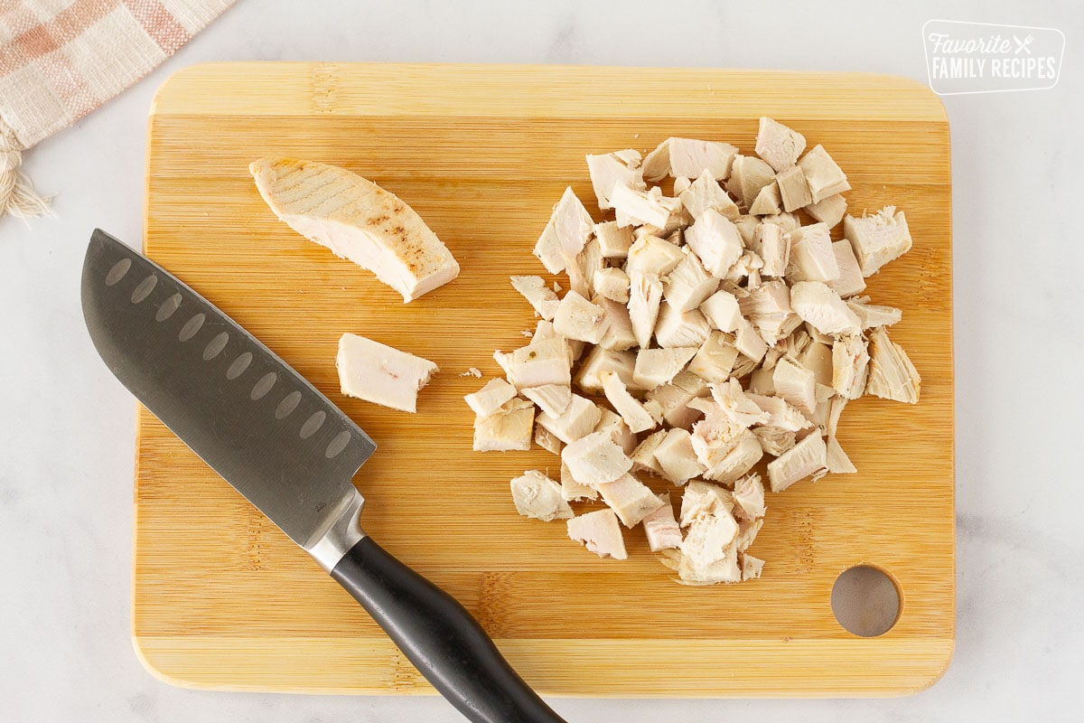 Cut up Turkey on a cutting board with a knife for Easy Pot Pie.