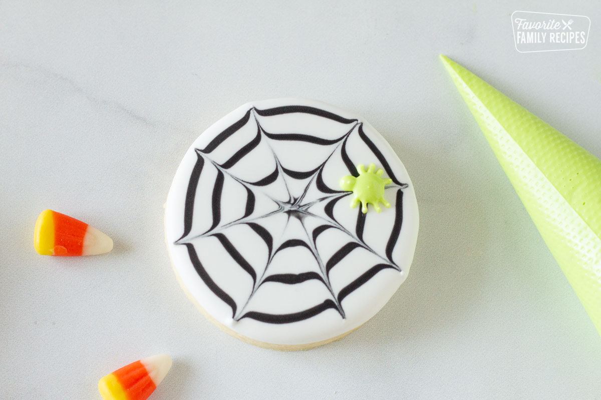 Decorated spider web Halloween Cookie with a green spider.