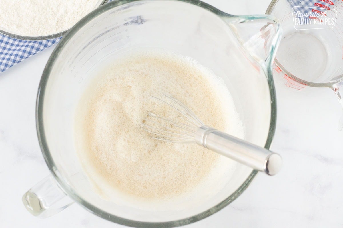 Foamy bowl of yeast with water to make Subway Bread.