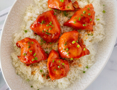 Full platter of Instant Pot Apricot Chicken topped with green onions and served over rice.
