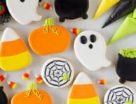 Ghosts, cauldron, spider web, pumpkin and candy corn Halloween Cookies. Piping bags of icing on the side.