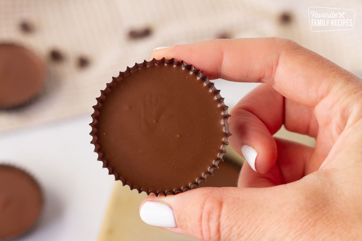Hand holding a completed single Homemade Reese's Peanut Butter Cup.