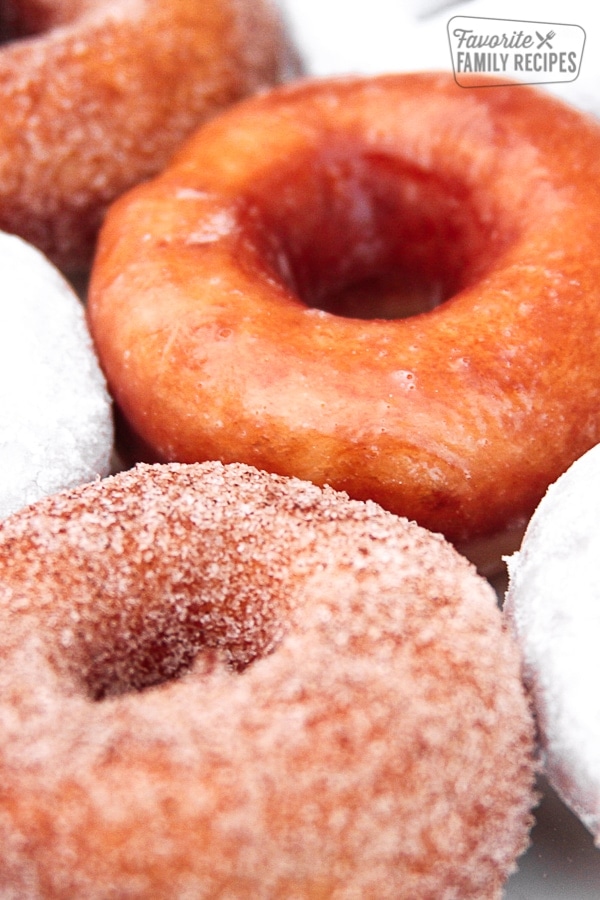 Homemade donuts with powdered sugar, cinnamon sugar, and glaze.
