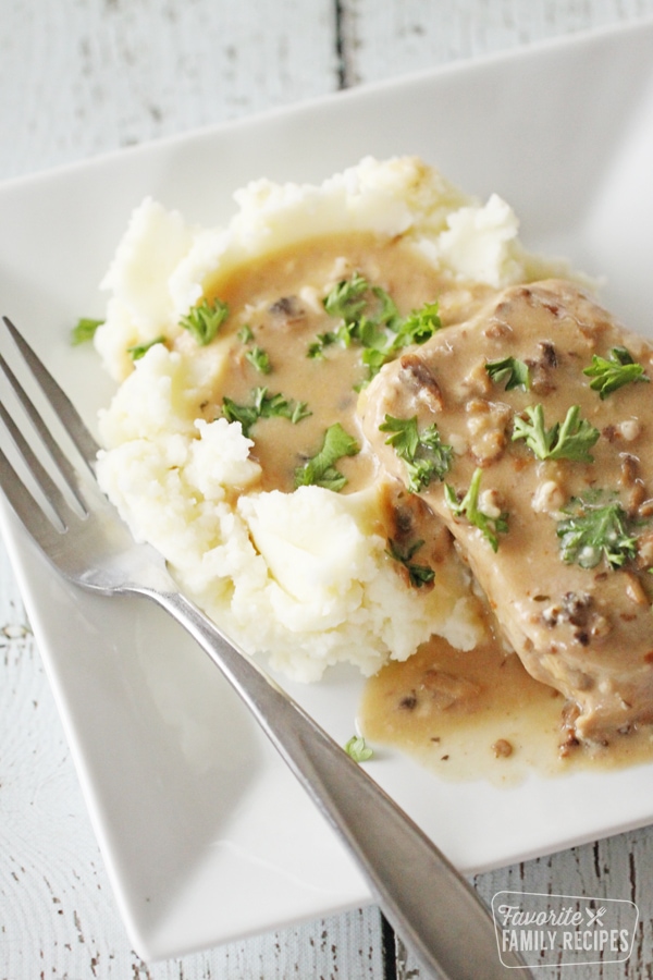A plate with potatoes, gravy, and a pork chop cooked in the instant pot