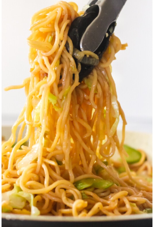 Tongs pulling up Panda Express chow mein noodles from a pan to show length