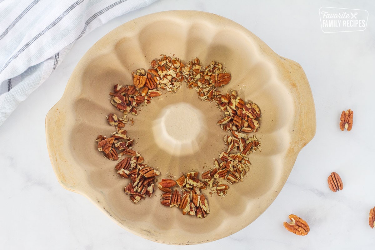 Chopped pecans in the bottom of a bundt pan for Easy Monkey Bread.