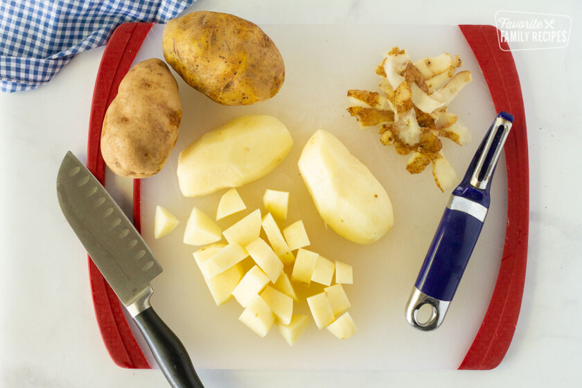 Peeled and sliced potatoes on a cutting board to make Easy Shepherd's Pie.