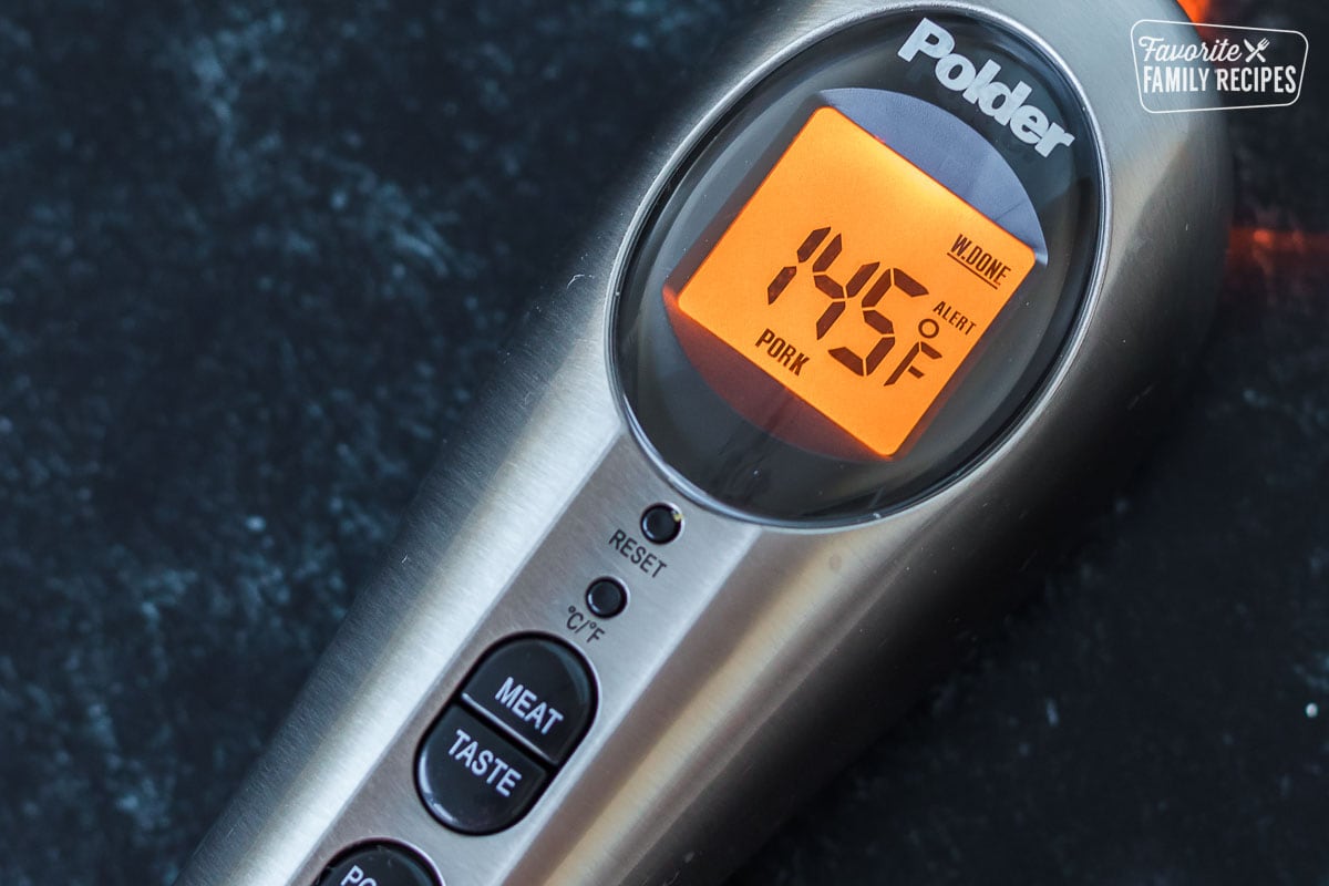 A meat thermometer showing 145 degrees on the digital screen