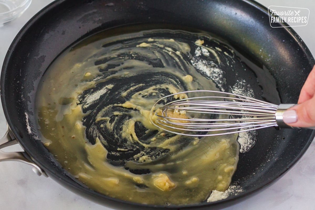 Pan with a whisk making a roux for Green Bean Casserole sauce.