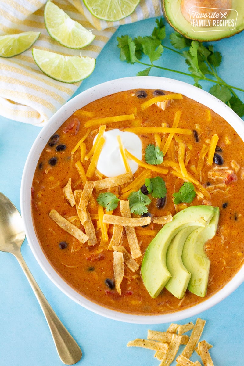 Single bowl of Cafe Zupas Chicken Enchilada Chili garnished with avocado, sour cream, cheese and cilantro.