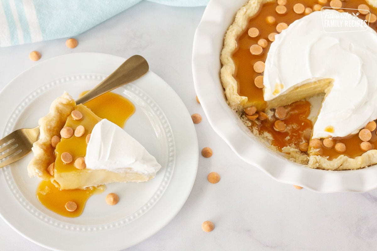 Slice of Butterscotch Pie on a plate next to the Butterscotch pie missing a slice.