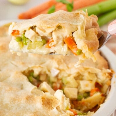Spatula holding a slice of Easy Turkey Pot Pie over the whole Turkey Pot Pie.